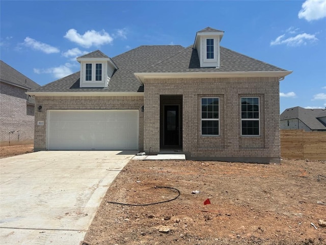 8217 Grenadier Dr, Austin, TX 78738 - view of front of house featuring brick siding, a garage, concrete driveway, and roof with shingles