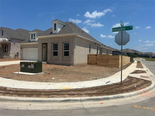 8217 Grenadier Dr, Austin, TX 78738 - view of front facade featuring brick siding, an attached garage, and a shingled roof
