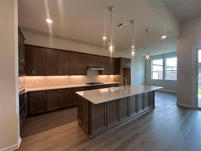 8217 Grenadier Dr, Austin, TX 78738 - kitchen with dark wood-style flooring, dark brown cabinets, decorative backsplash, and recessed lighting