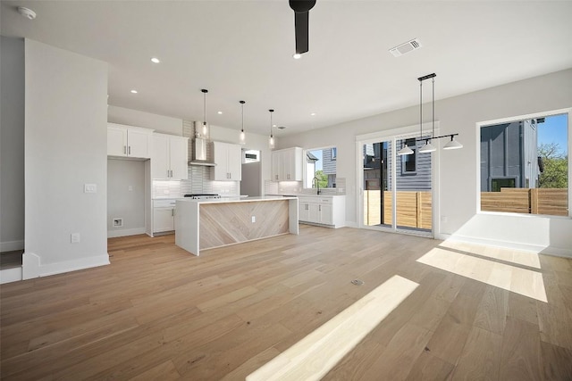 6301 Bristol Cir Unit 1, Austin, TX 78723 - kitchen with light wood-style flooring, white cabinets, decorative backsplash, light countertops, and recessed lighting