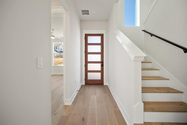 6301 Bristol Cir Unit 1, Austin, TX 78723 - foyer entrance featuring light wood finished floors, plenty of natural light, baseboards, and stairway