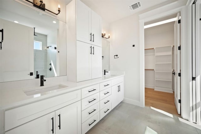 6301 Bristol Cir Unit 1, Austin, TX 78723 - bathroom featuring a shower stall, double vanity, a spacious closet, and baseboards