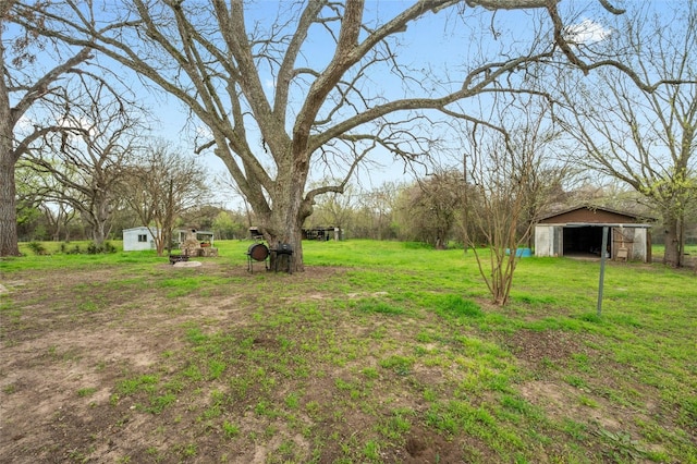 view of yard with an outbuilding, a detached garage, and an outdoor structure