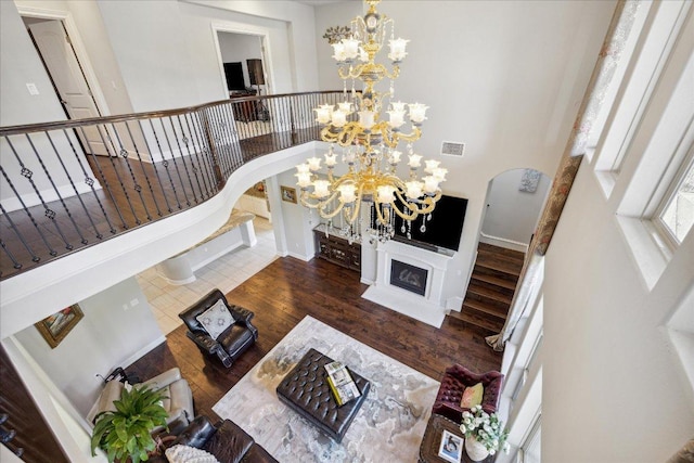 1600 Morning Moon Cir, Austin, TX 78732 - living room with a chandelier, arched walkways, stairs, and wood finished floors