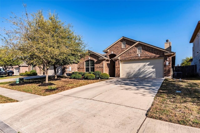 351 Still Hollow Crk, Buda, TX 78610 - view of front facade with an attached garage, brick siding, driveway, and a chimney