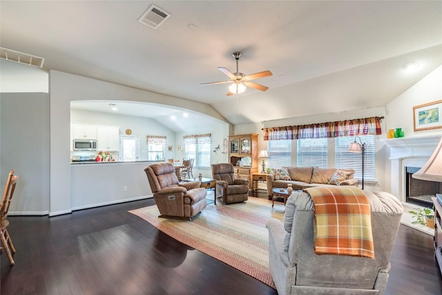 351 Still Hollow Crk, Buda, TX 78610 - living area featuring vaulted ceiling, arched walkways, a ceiling fan, wood finished floors, and a fireplace