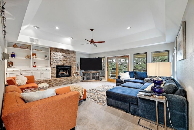 409 Hurst Creek Rd, Lakeway, TX 78734 - living room featuring a tray ceiling, carpet flooring, ceiling fan, a stone fireplace, and recessed lighting