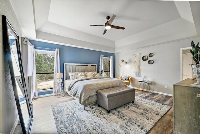 409 Hurst Creek Rd, Lakeway, TX 78734 - bedroom featuring a raised ceiling, wood finished floors, ceiling fan, and baseboards