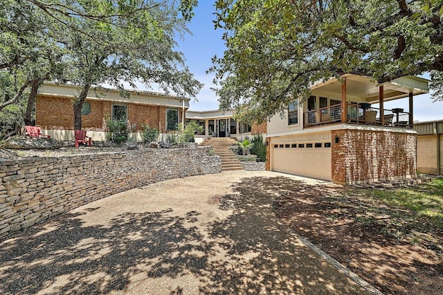 409 Hurst Creek Rd, Lakeway, TX 78734 - ranch-style home with a balcony, an attached garage, stairway, brick siding, and concrete driveway