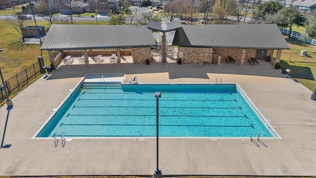 community pool with a residential view, a patio area, and fence