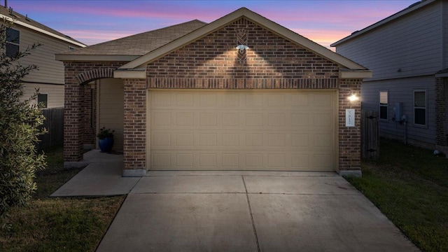 view of front of house featuring concrete driveway, brick siding, and a garage