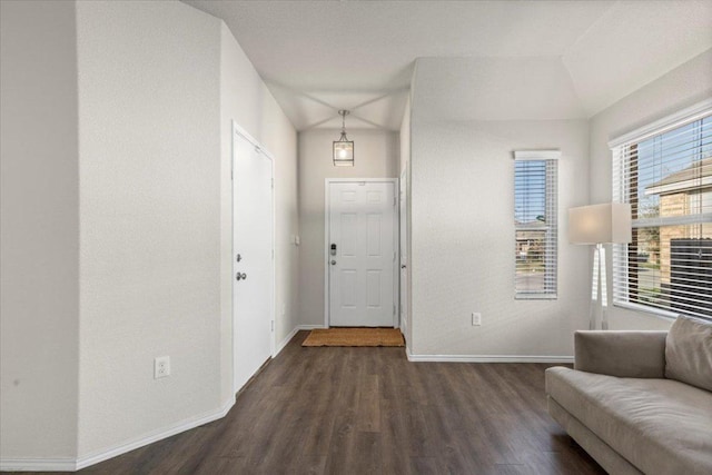 foyer featuring baseboards and dark wood-style floors
