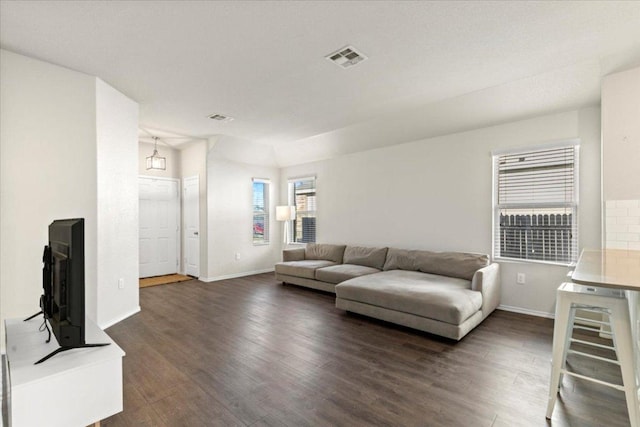 living area with dark wood finished floors, baseboards, and visible vents