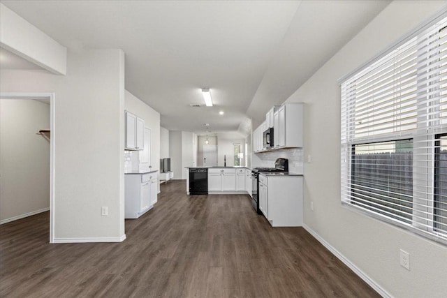 kitchen featuring a peninsula, baseboards, black appliances, and dark wood-style flooring