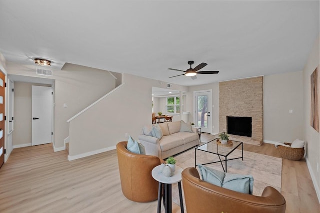 3005 Canter Ln, Austin, TX 78759 - living room with stairway, light wood-style flooring, baseboards, a ceiling fan, and a stone fireplace
