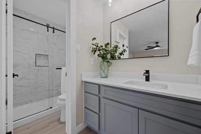 3005 Canter Ln, Austin, TX 78759 - full bath with toilet, vanity, a marble finish shower, a ceiling fan, and wood finished floors