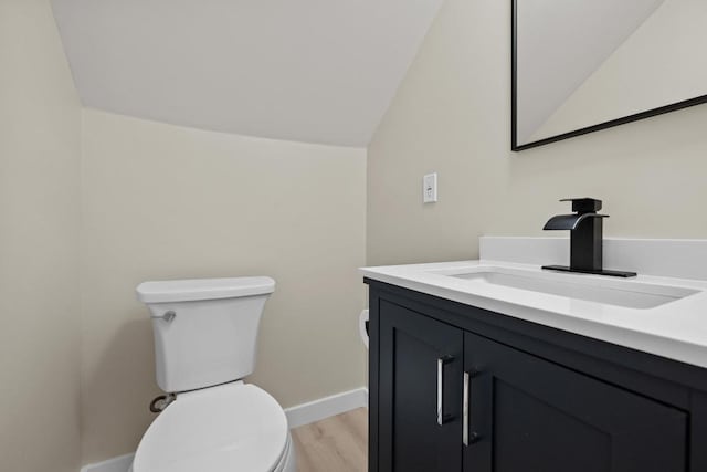 3005 Canter Ln, Austin, TX 78759 - half bathroom featuring toilet, vanity, lofted ceiling, wood finished floors, and baseboards