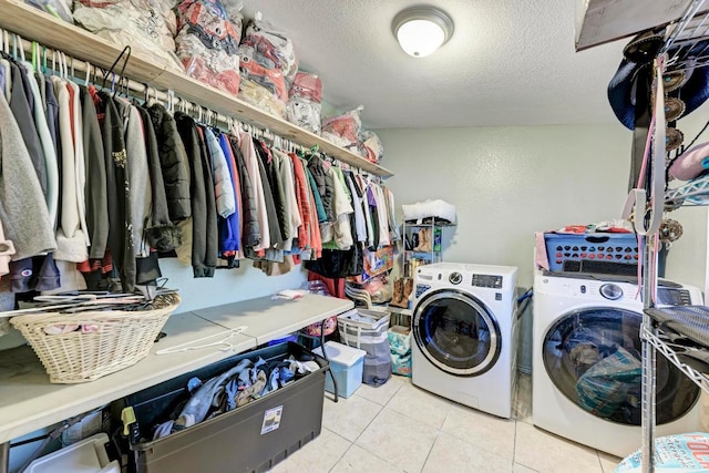 laundry area featuring washer and clothes dryer, tile patterned floors, laundry area, and a textured ceiling