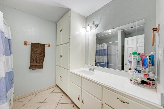 full bath featuring vanity, baseboards, a textured wall, tile patterned floors, and a shower with curtain