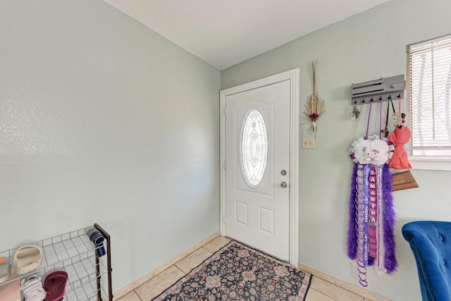 entryway with light tile patterned floors and baseboards