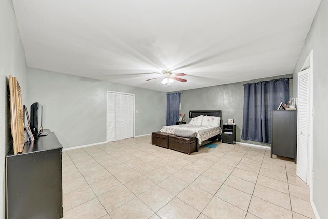 bedroom featuring baseboards, a ceiling fan, and light tile patterned flooring