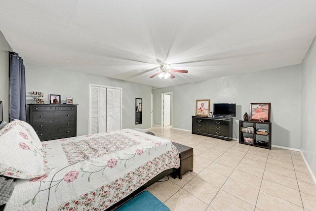 tiled bedroom featuring baseboards, a closet, and a ceiling fan