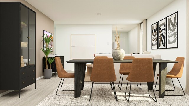 dining space with light wood finished floors and baseboards
