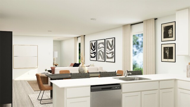 kitchen featuring a sink, dishwasher, a peninsula, white cabinets, and light wood-style floors