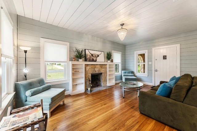 2310 Euclid Ave, Austin, TX 78704 - living room with wood finished floors, a fireplace, wooden walls, a chandelier, and wood ceiling