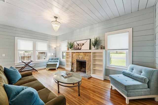 2310 Euclid Ave, Austin, TX 78704 - living area with wood finished floors, wood walls, a stone fireplace, and a chandelier