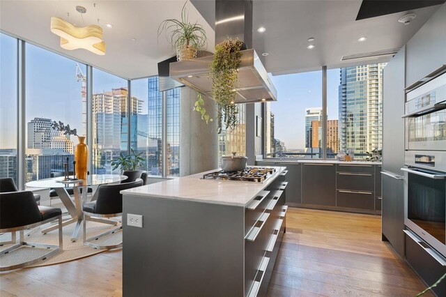 210 Lavaca St Unit 2312, Austin, TX 78701 - kitchen with a view of city, modern cabinets, stainless steel appliances, and island range hood