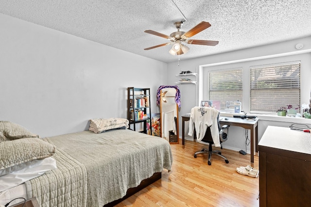 2110 Rio Grande St Unit 207, Austin, TX 78705 - bedroom featuring light wood-style flooring, a textured ceiling, a desk, and a ceiling fan