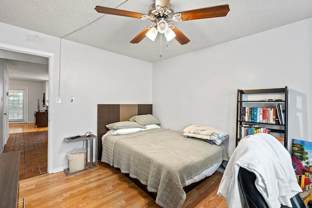 2110 Rio Grande St Unit 207, Austin, TX 78705 - bedroom with light wood finished floors, a textured ceiling, and a ceiling fan