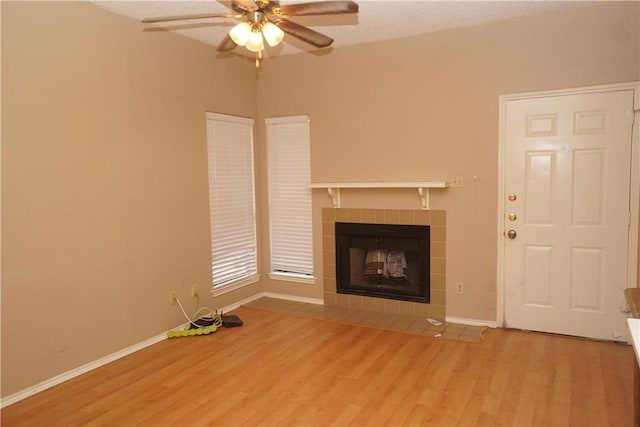 2706 Salado St Unit 210, Austin, TX 78705 - unfurnished living room with wood finished floors, ceiling fan, and a tiled fireplace