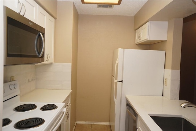 2706 Salado St Unit 210, Austin, TX 78705 - kitchen featuring appliances with stainless steel finishes, white cabinets, light countertops, and backsplash