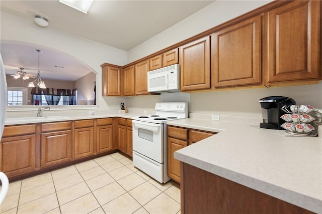 211 Almquist St, Hutto, TX 78634 - kitchen with white appliances, brown cabinetry, light countertops, light tile patterned floors, and ceiling fan