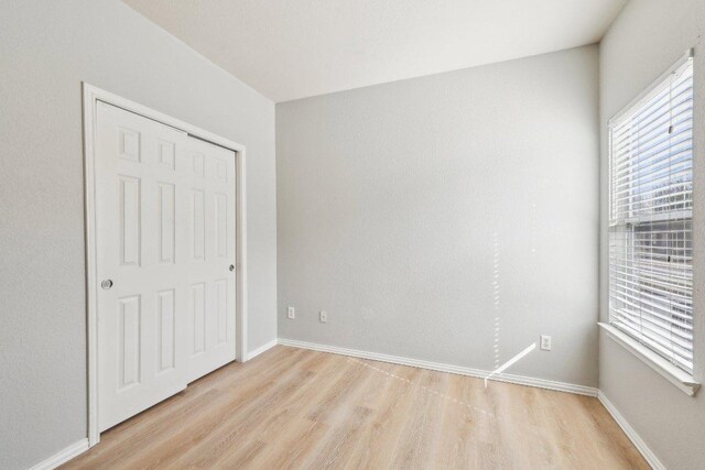 211 Almquist St, Hutto, TX 78634 - unfurnished bedroom featuring light wood-type flooring, multiple windows, and a closet