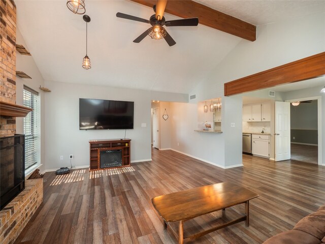 100 Stubblefield Dr, Elgin, TX 78621 - living room with a large fireplace, ceiling fan, beam ceiling, wood finished floors, and high vaulted ceiling