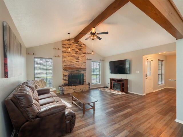 100 Stubblefield Dr, Elgin, TX 78621 - living area featuring a brick fireplace, wood-type flooring, beamed ceiling, a ceiling fan, and high vaulted ceiling