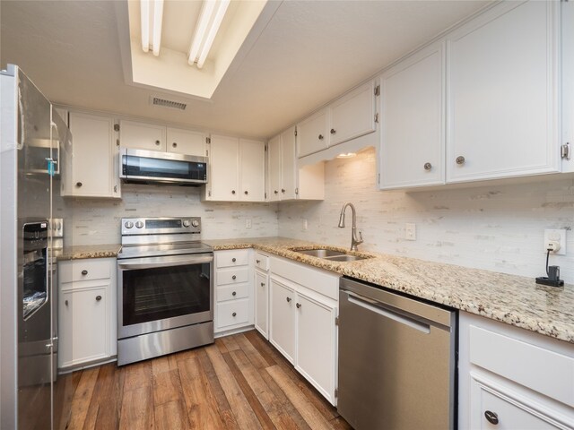 100 Stubblefield Dr, Elgin, TX 78621 - kitchen with stainless steel appliances, wood finished floors, and white cabinetry