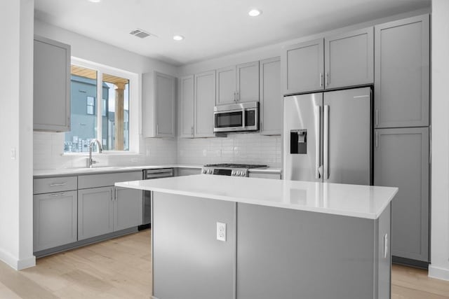 2209 Mcfly Pl, Austin, TX 78723 - kitchen featuring stainless steel appliances, gray cabinets, light wood-style flooring, and recessed lighting