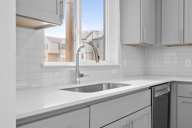2209 Mcfly Pl, Austin, TX 78723 - kitchen featuring stainless steel dishwasher, a sink, backsplash, and light countertops