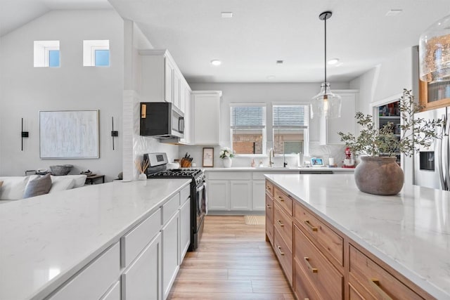 5833 Bianca Dr, Round Rock, TX 78665 - kitchen with appliances with stainless steel finishes, light wood finished floors, plenty of natural light, light stone countertops, and recessed lighting
