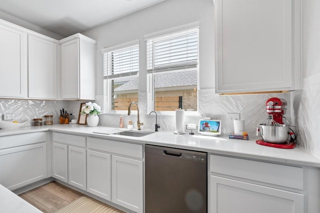 kitchen with a sink, light countertops, white cabinetry, backsplash, and stainless steel dishwasher