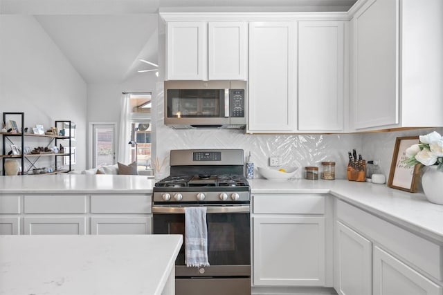 5833 Bianca Dr, Round Rock, TX 78665 - kitchen featuring stainless steel appliances, backsplash, white cabinetry, light countertops, and lofted ceiling