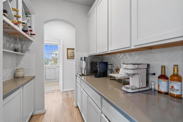 5833 Bianca Dr, Round Rock, TX 78665 - kitchen with arched walkways, open shelves, decorative backsplash, and light wood-type flooring