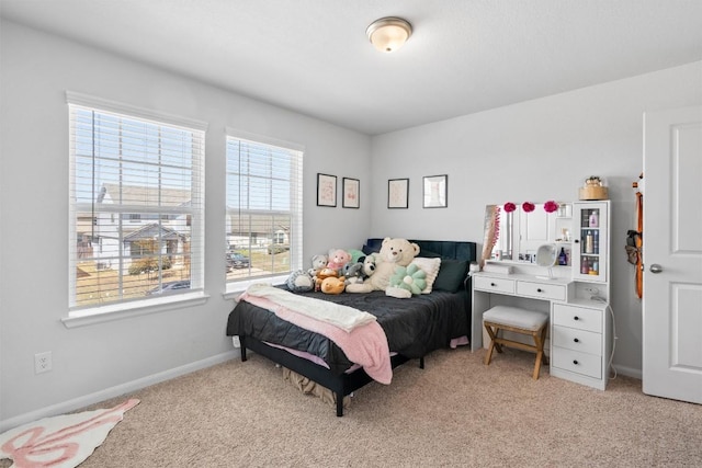 bedroom with baseboards and light carpet