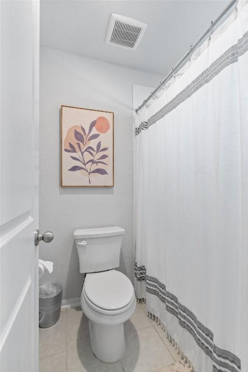 bathroom featuring toilet, visible vents, and tile patterned flooring