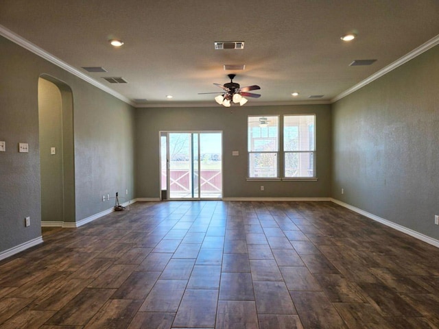empty room with visible vents, arched walkways, ornamental molding, and a ceiling fan