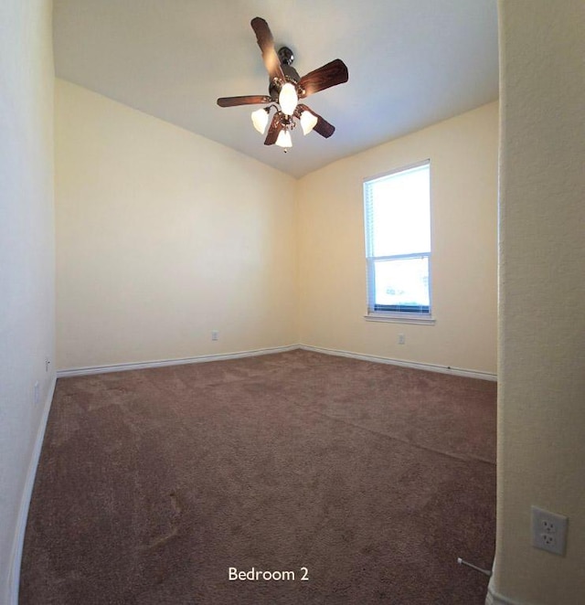 empty room featuring a ceiling fan, carpet, and baseboards
